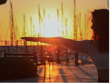Woman stretching outdoors at sunset.